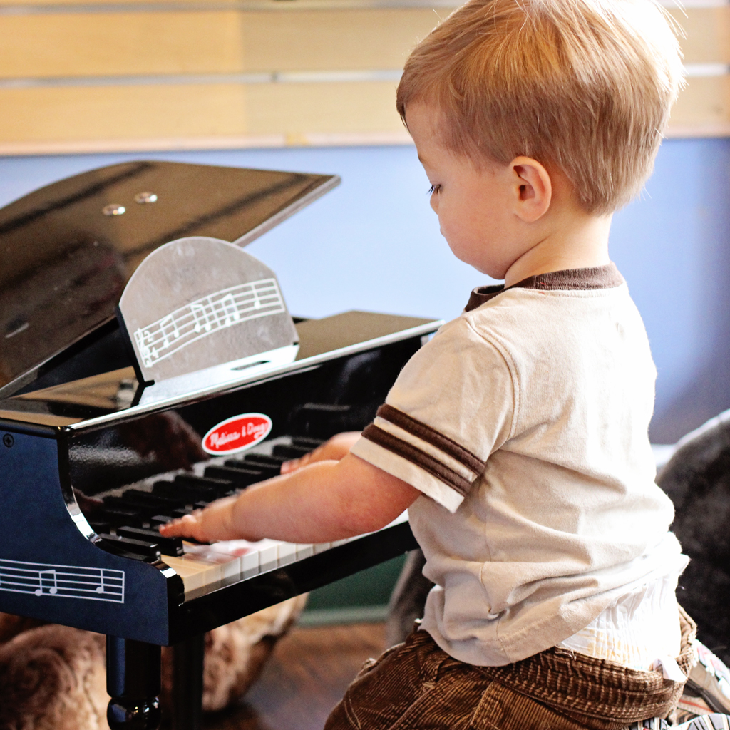 baby-boy-playing-childs-piano-in-the-store-window